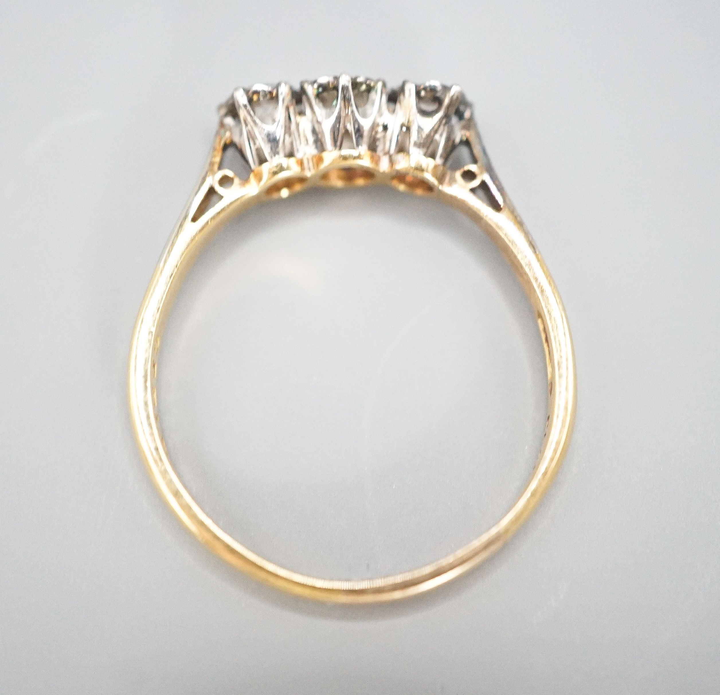 A modern 18ct gold and three stone diamond ring, size Q/R, gross weight 3 grams.